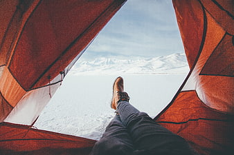 POV from inside orange tent looking at snowy mountains