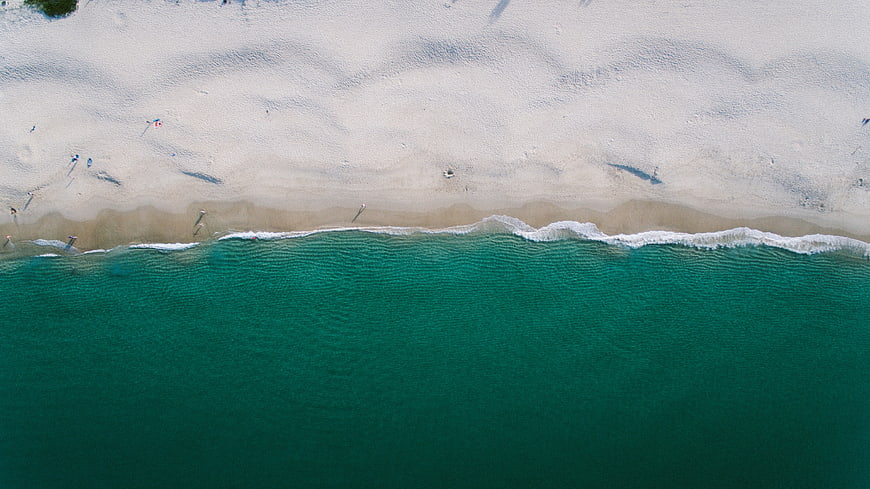 Aerial View of Turquoise Ocean Waves Meeting White Sandy Beach