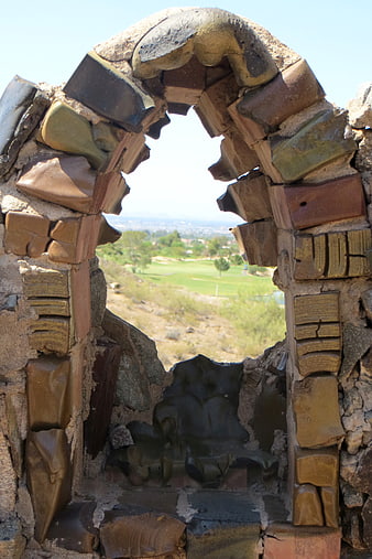 Rustic stone archway framing a scenic golf course view