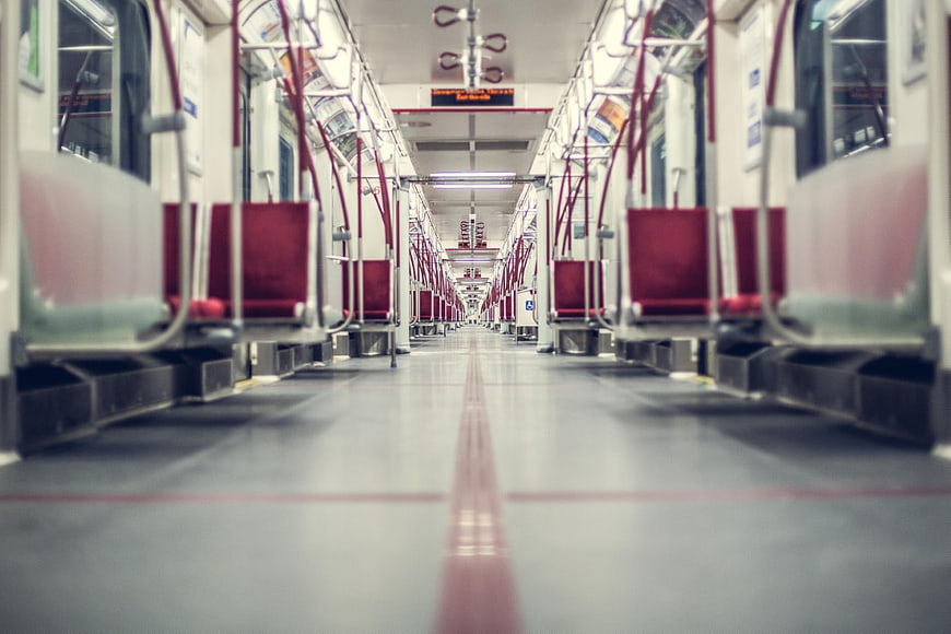 Empty subway train interior with red seats and perspective view