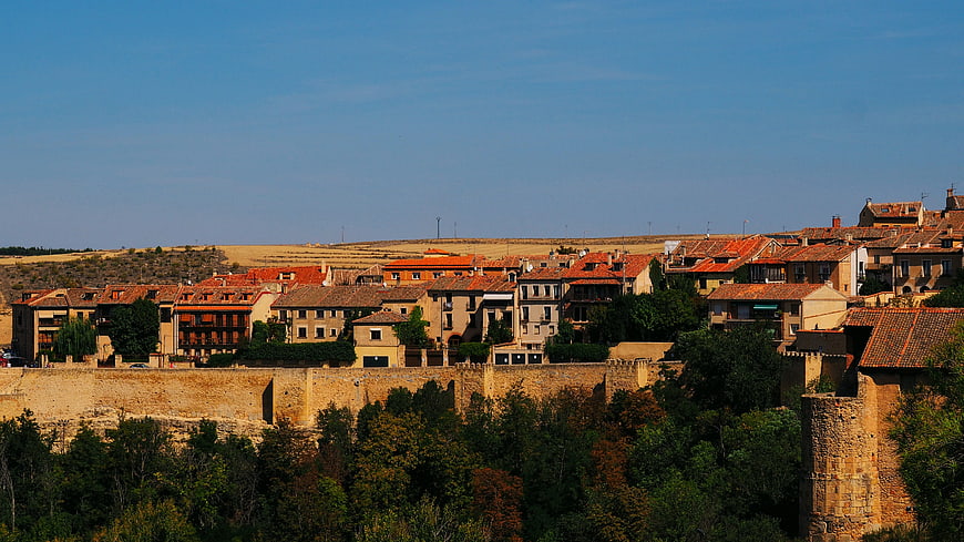 Historic walled town with terracotta rooftops and autumn trees