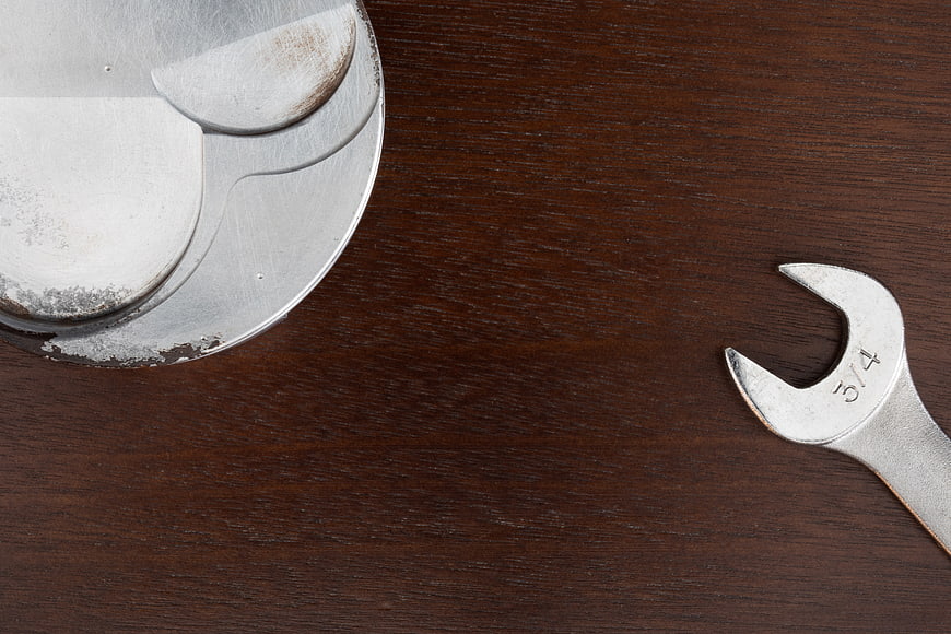 Wrench and Piston on Wooden Workshop Table