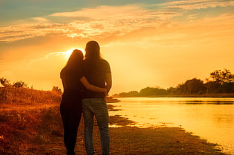 Couple Silhouette Embracing at Sunset by a River
