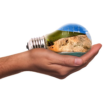 Hand holding lightbulb with wind turbines and nature scene