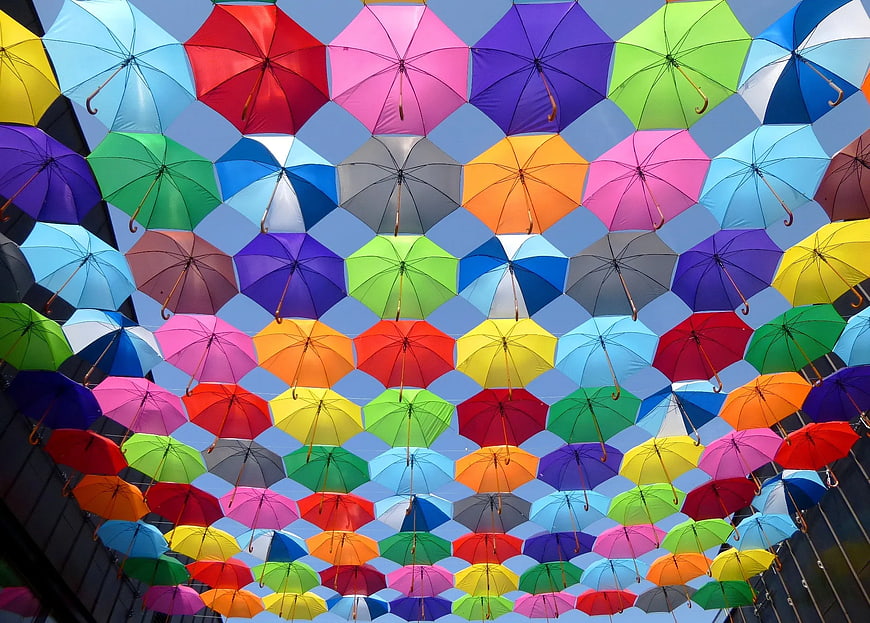 Colorful Open Umbrellas Hanging Against Blue Sky