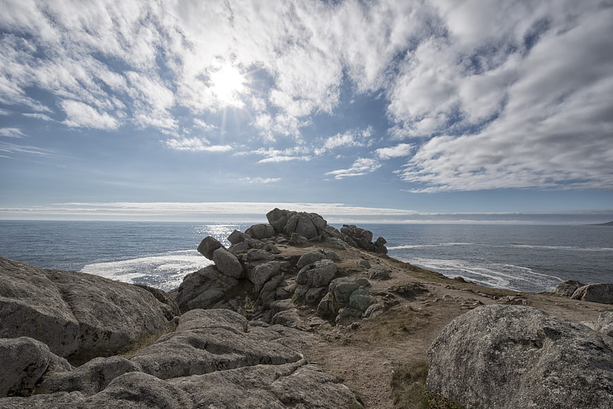 Rugged Rocky Coastline with Blue Ocean and Cloudy Sky