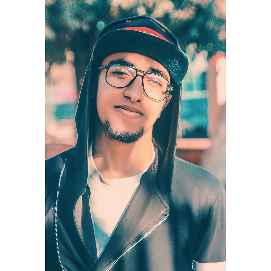 Portrait of young man in hoodie and glasses outdoors