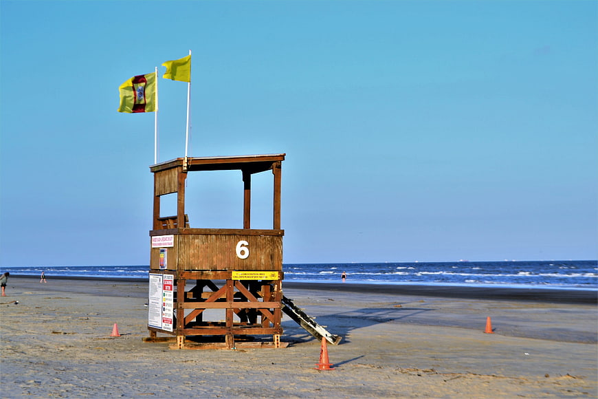 Wooden Lifeguard Tower on Sandy Beach with Flags
