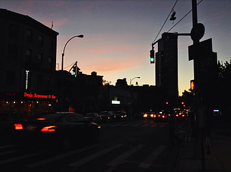 City street traffic at dusk with sunset sky