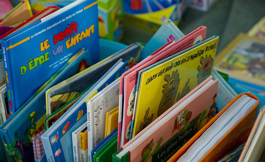 Colorful French Children's Books Displayed In Market Bins