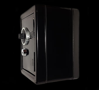 Black Miniature Safe with Combination Lock on Dark Background