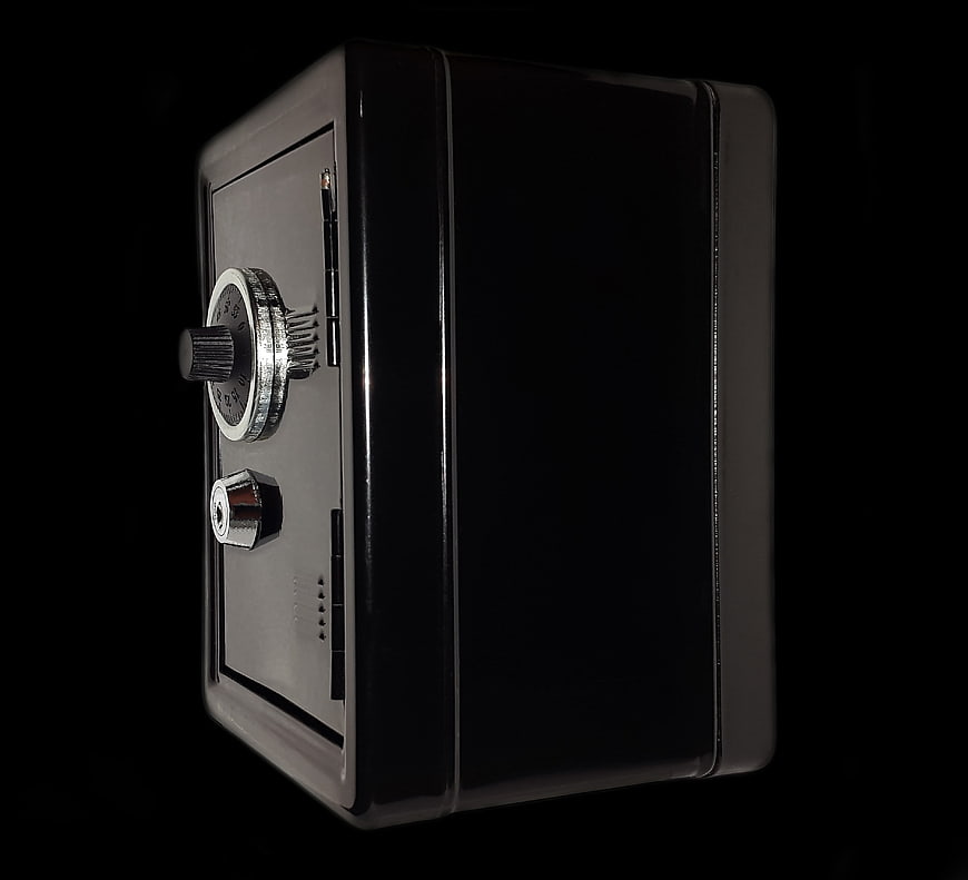 Black Miniature Safe with Combination Lock on Dark Background