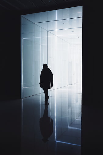 Silhouette of man walking in futuristic neon corridor