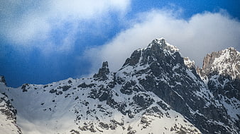 Majestic Snow-Capped Mountain Peak with Blue Sky and Clouds
