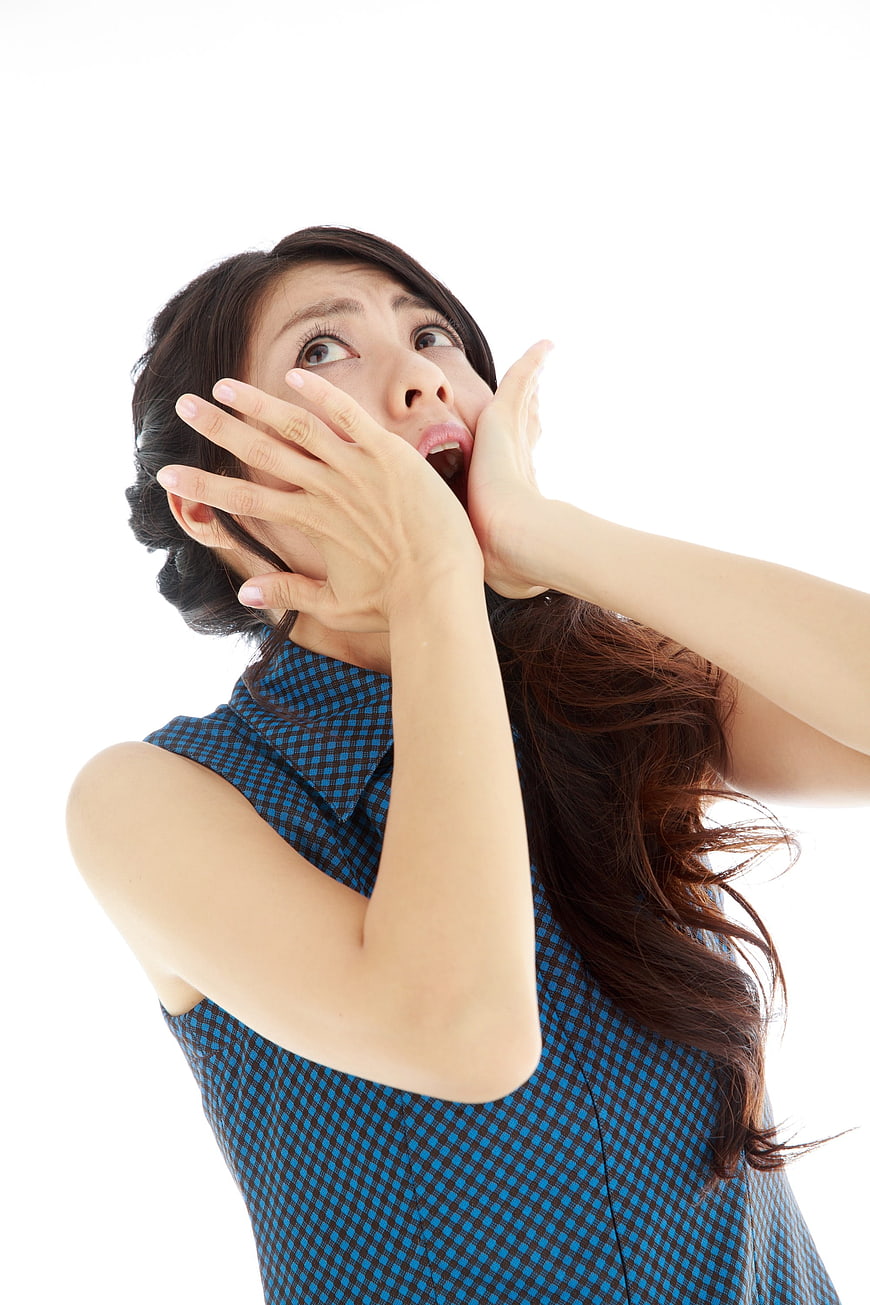 Shocked Asian Woman Screaming with Hands on Face