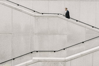 Man in Suit Walking Down Minimalist Concrete Stairs