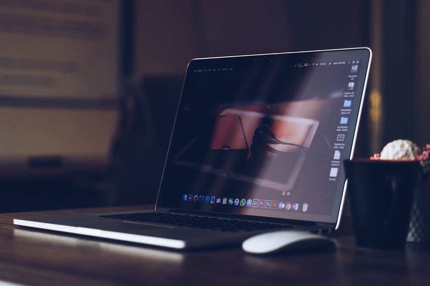 Laptop on Wooden Desk with Mouse and Plant