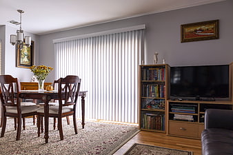 Bright Living Room with Vertical Blinds and Dining Set