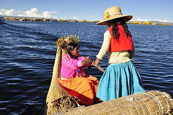 Uru women in traditional dress on a reed boat on Lake Titicaca