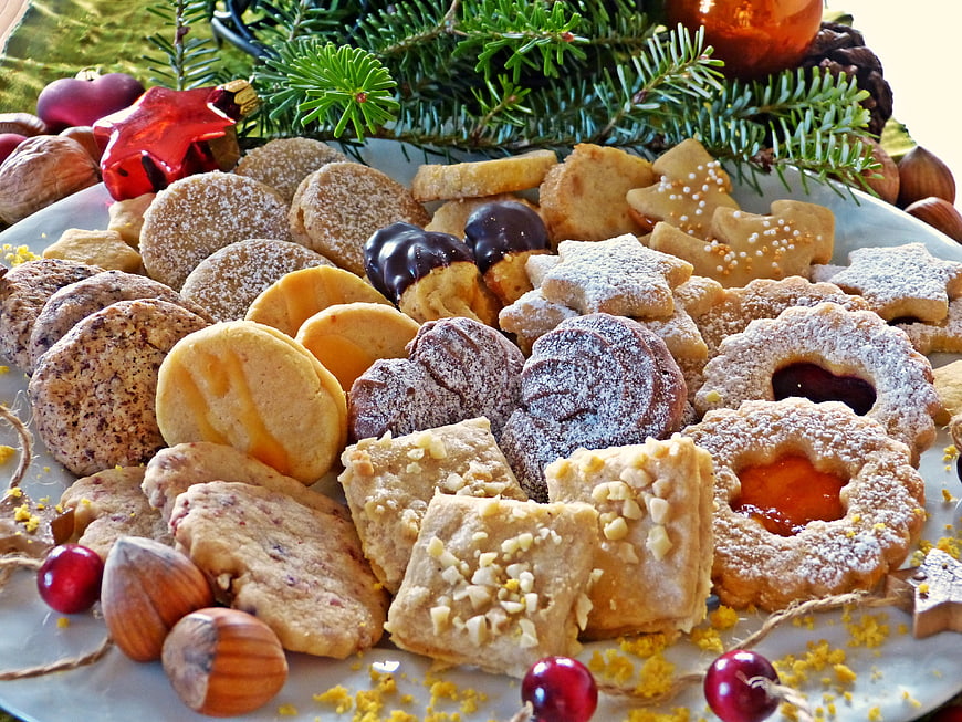 Assorted Christmas Cookies on Plate with Pine Branches and Hazelnuts