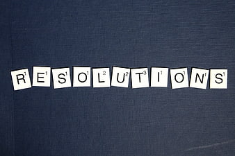 Scrabble Tiles Spelling Resolutions on Blue Background