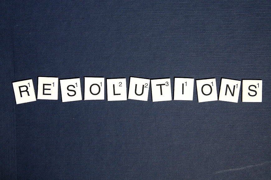 Scrabble Tiles Spelling Resolutions on Blue Background