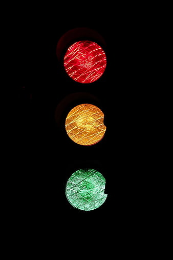 Close-up of red, yellow, and green traffic lights at night