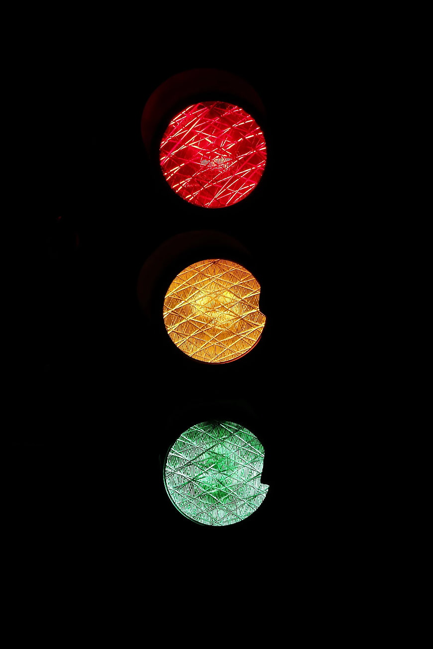 Close-up of red, yellow, and green traffic lights at night