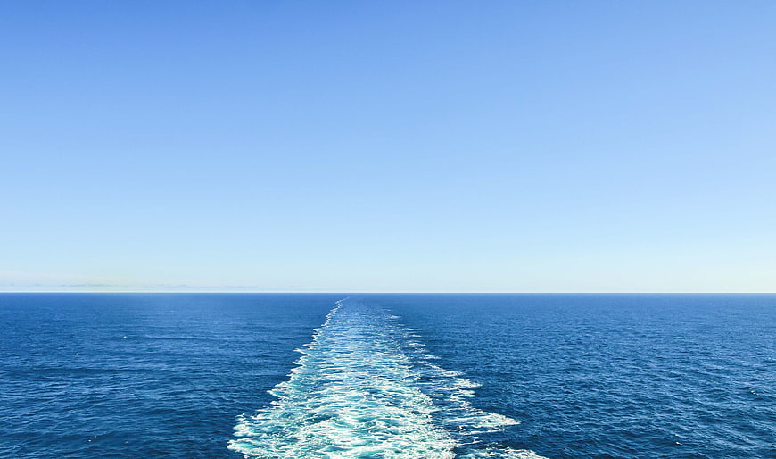 Boat Wake Trail on Deep Blue Ocean Horizon