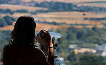 Woman Silhouette Using Coin-Operated Binoculars at Scenic Viewpoint