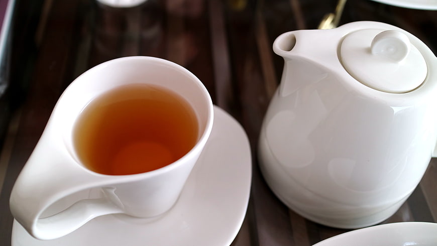 White Ceramic Teapot and Cup of Oolong Tea on Wooden Table