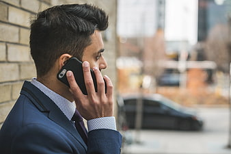 Businessman in Blue Suit Talking on Smartphone Outdoors