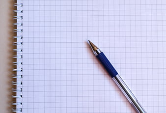 Blue mechanical pencil on blank grid notebook page