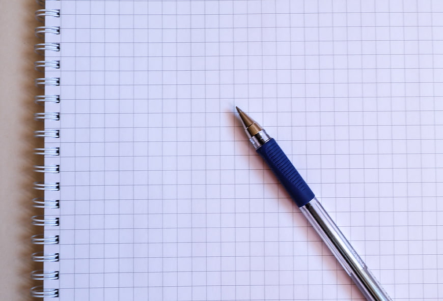 Blue mechanical pencil on blank grid notebook page