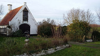 White brick chapel with red roof in garden
