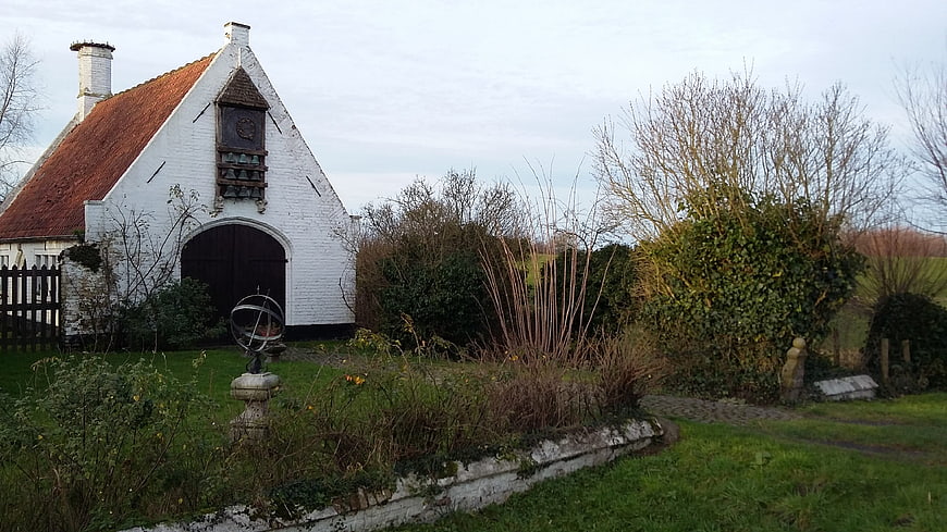 White brick chapel with red roof in garden