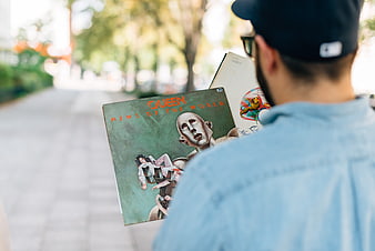 Man holding Queen vinyl record on street