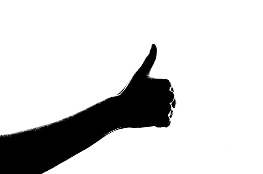 Black Silhouette Of Hand Giving Thumbs Up On White Background