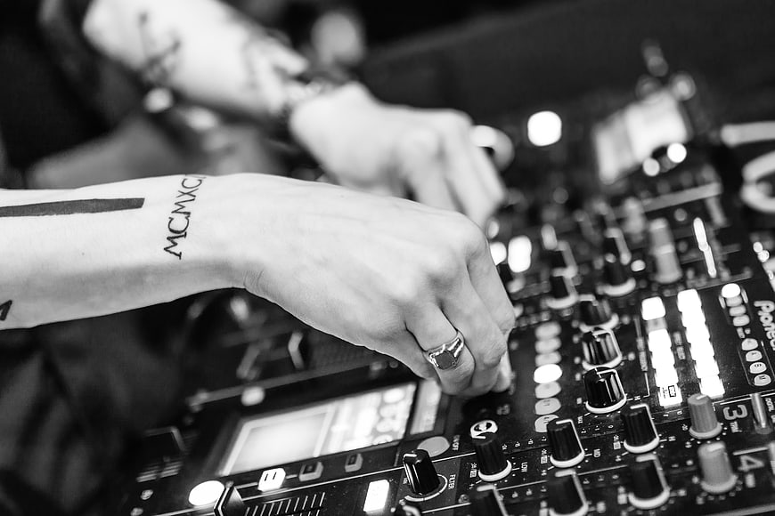 Close-up of DJ hands mixing on Pioneer controller