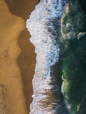 Aerial View of Ocean Waves Crashing on Sandy Beach