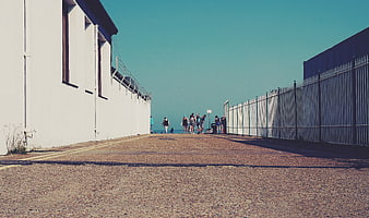 Low angle view of people walking down a coastal path to the sea