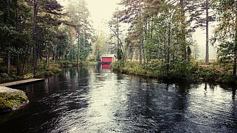 Serene River Landscape with Red Boathouse in Forest