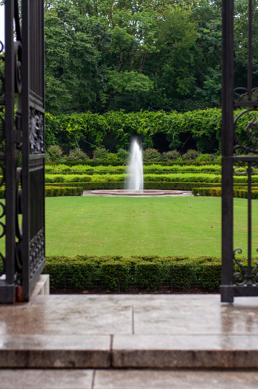 Manicured Garden View Through Ornate Iron Gate
