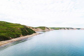 Aerial View of Green Coastal Cliffs and Calm Ocean