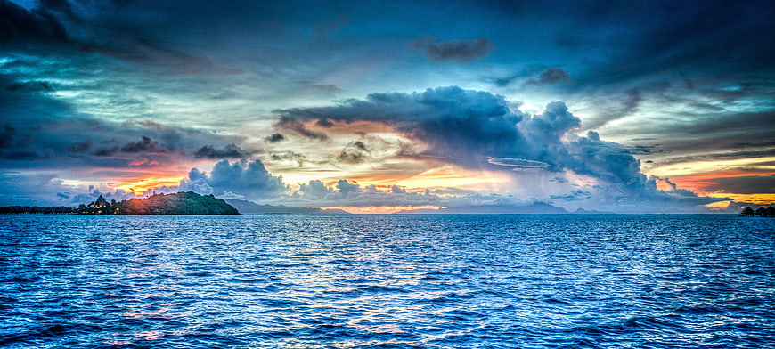 Dramatic Sunset Over Tropical Ocean with Island Silhouette