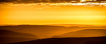 Golden Sunrise Over Misty Rolling Hills Landscape