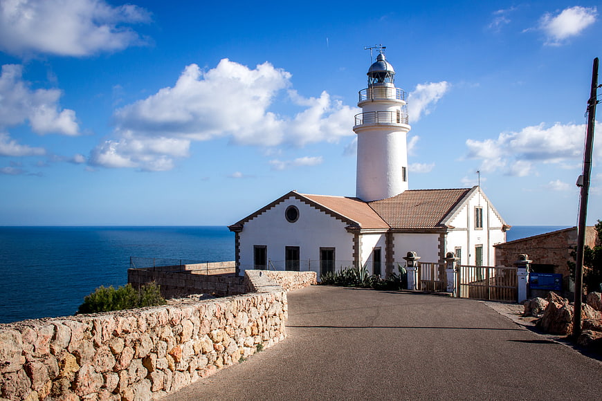 White Lighthouse on Coastal Cliff with Blue Ocean View