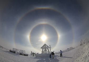 Winter Sun Halo Phenomenon Over Snowy Mountain Landscape