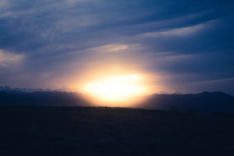 Dramatic Sunrise Over Mountain Range with Clouds