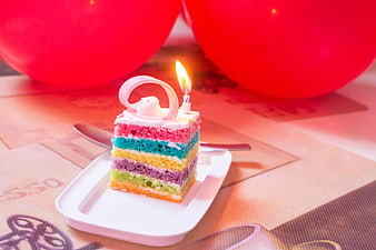 Colorful Rainbow Birthday Cake Slice with Candle and Balloons